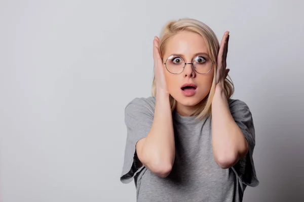 Serious blonde woman in glasses on white background — Stock Photo, Image