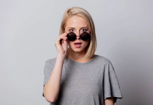 Mujer rubia seria en gafas de sol sobre fondo blanco — Foto de Stock