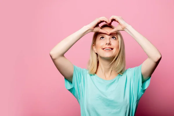 Bela mulher mostrar gesto de amor no fundo rosa — Fotografia de Stock