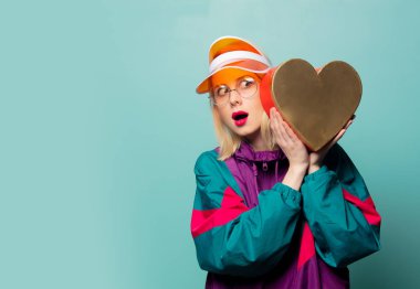 Aqua Menthe arka planında kalp şeklinde hediyesi olan tarz bir kadın.