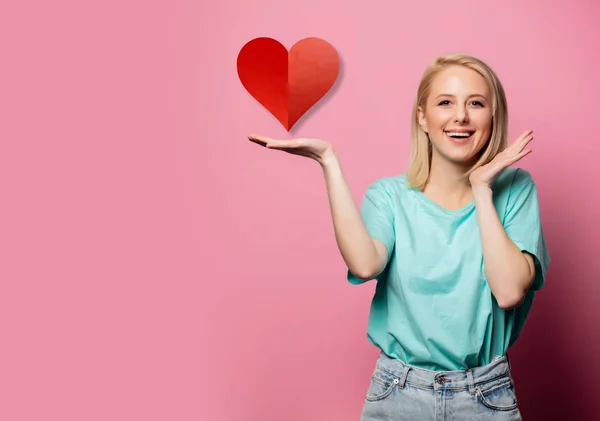 Schöne lächelnde Frau mit Herzform Zeichen auf rosa Hintergrund — Stockfoto