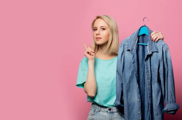 Mulher bonita com camisa em ahanger no fundo rosa — Fotografia de Stock