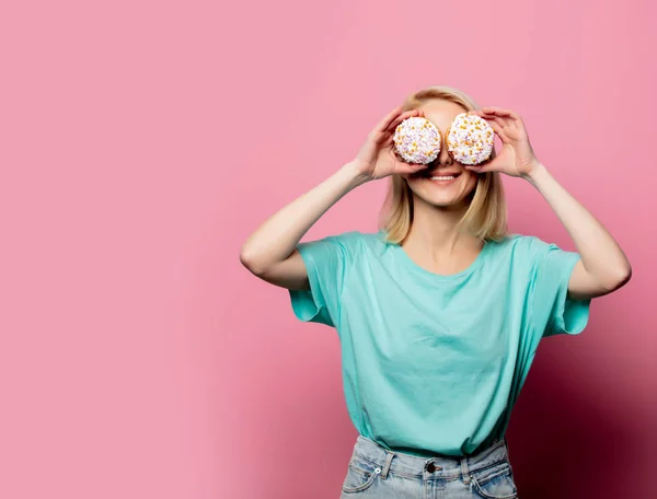 Mulher loira bonita com donut no fundo rosa — Fotografia de Stock