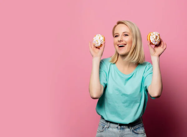 Beautiful blonde woman with donut on pink background — 스톡 사진
