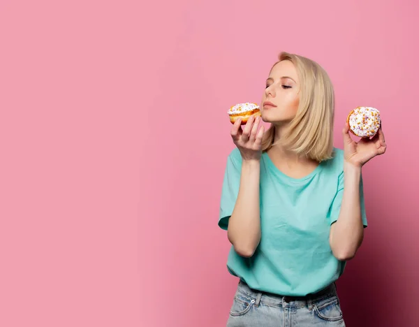 Beautiful blonde woman with donut on pink background — 스톡 사진