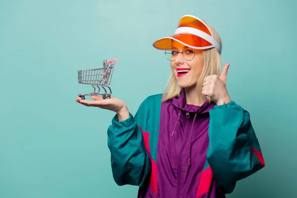 Estilo mujer rubia en traje deportivo de los años 90 con carrito de compras — Foto de Stock
