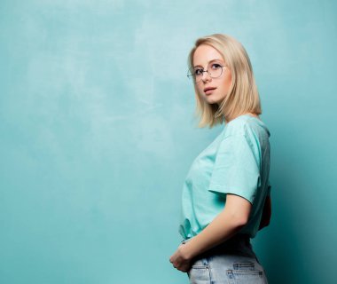 Style blonde woman in glasses on blue background