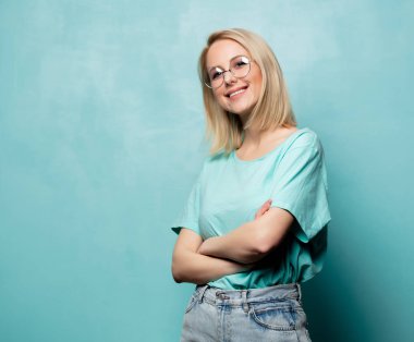 Style smiling blonde woman in glasses on blue background