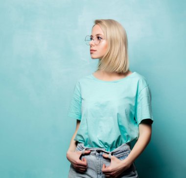 Style blonde woman in glasses on blue background