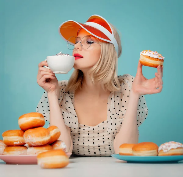 Mooie vrouw in jaren '90 kleding met donuts en koffie — Stockfoto