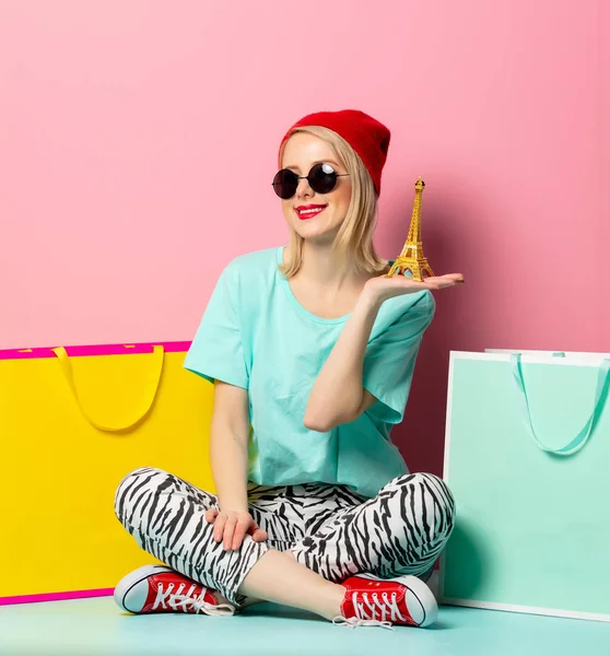 Stijl vrouw in zonnebril met boodschappentassen en kleine Eiffel t — Stockfoto