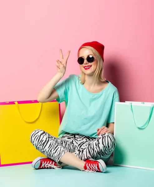 Stijl vrouw in zonnebril met boodschappentassen — Stockfoto
