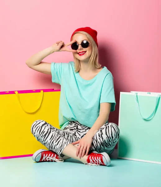 Mujer de estilo en gafas de sol con bolsas de compras —  Fotos de Stock