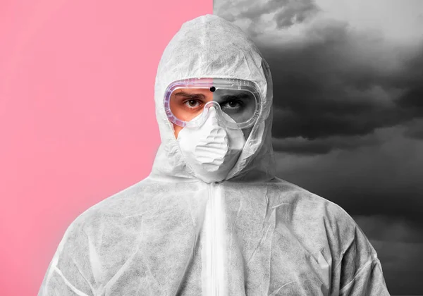 Man in a protective suit and mask on a pink background with a th — Stok fotoğraf