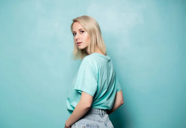 Mooie blonde vrouw op blauwe achtergrond — Stockfoto