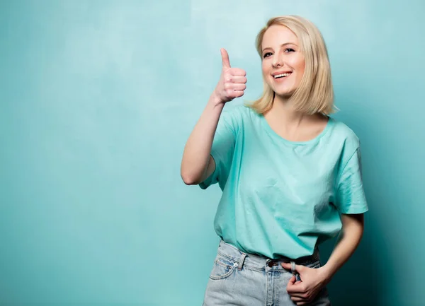 Beautiful blonde woman show OK gesture on blue background — Stockfoto