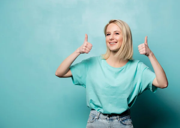 Beautiful blonde woman show OK gesture on blue background — Stockfoto