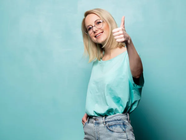 Style blonde woman in glasses show OK gesture on blue background — Stockfoto