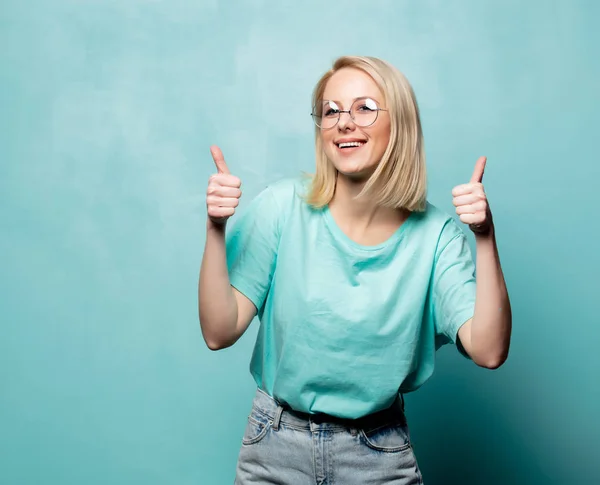 Style femme blonde dans des lunettes montrer OK geste sur fond bleu — Photo