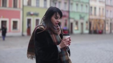 Esmer kadın eski kasabada bir fincan kahveyle 