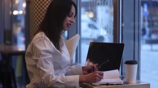カフェで働いているラップトップコンピュータを持つブルネットの女性 — ストック動画