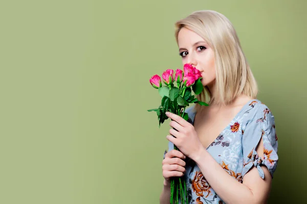 Beautiful blonde woman in dress with roses on green background — Stock Photo, Image