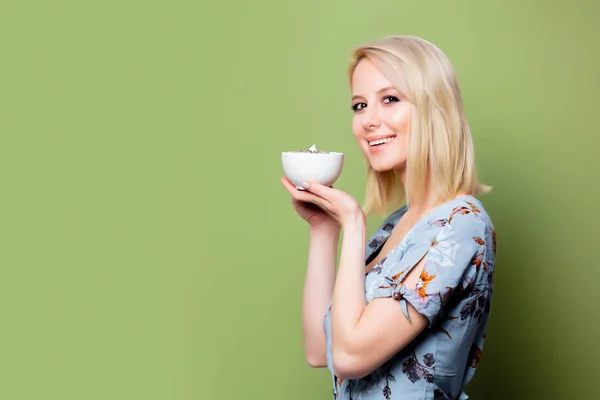 Blonde Frau im Kleid mit Tasse Kaffee auf grünem Hintergrund. St. — Stockfoto