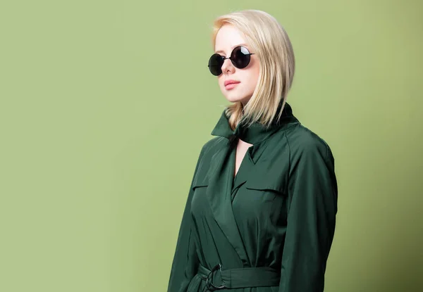 Blonde Frau Mantel Und Runder Sonnenbrille Auf Grünem Hintergrund — Stockfoto