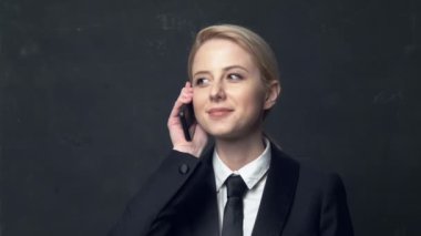 Klasik takım elbiseli bir iş kadını cep telefonuyla konuşuyor.