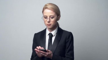 Klasik takım elbiseli bir iş kadını cep telefonuyla konuşuyor.