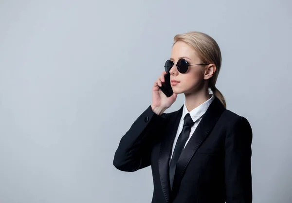 Klasik Siyah Takım Elbiseli Güneş Gözlüklü Bir Kadını Cep Telefonuyla — Stok fotoğraf
