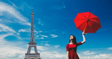 Eiffel Kulesi 'nin arka planında şemsiyesi olan kızıl saçlı güzel kız. 