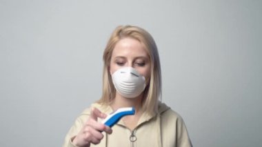 Maskeli kadın sıcaklığı ölçer