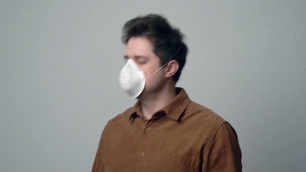 Man Een Masker Niest Een Grijze Achtergrond — Stockvideo