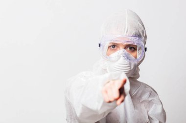 Koruyucu giysili genç bir doktor ve beyaz arka planda maskeli gözlükler.