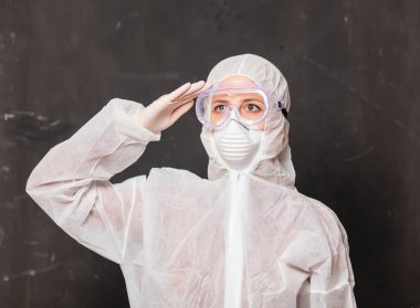 Koruyucu giysili kadın doktor ve maskeli gözlüklü.