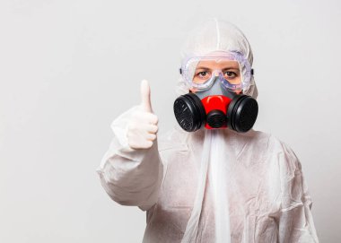 Koruyucu giysili kadın doktor ve maskeli gözlüklü.