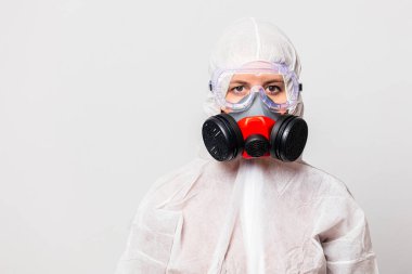Koruyucu giysili kadın doktor ve maskeli gözlüklü.