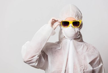 Koruyucu giysili kadın doktor ve maskeli güneş gözlüğü. 