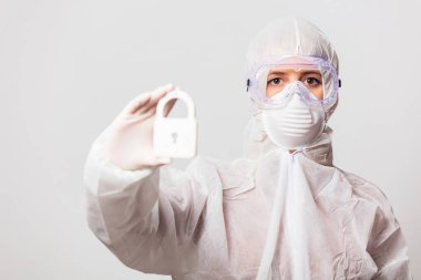 Koruyucu giysili kadın doktor ve maske takan gözlük kilit altında.