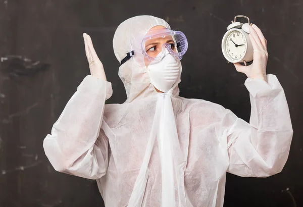 Doctora Traje Protección Gafas Con Máscara Sostiene Reloj Despertador —  Fotos de Stock