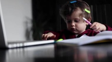 Küçük çocuk çalışan belgeler ve diğer ebeveyn araçlarıyla oynuyor.