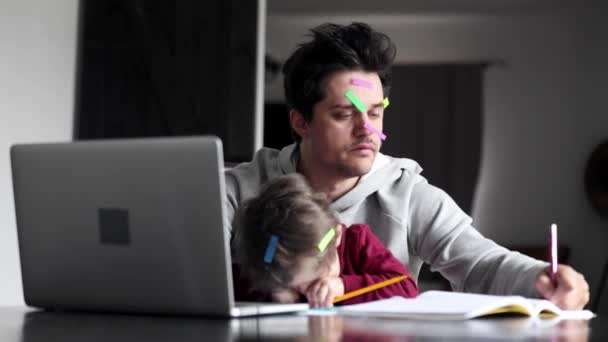 若い父親は子供と一緒に家のコンピュータで働いています — ストック動画