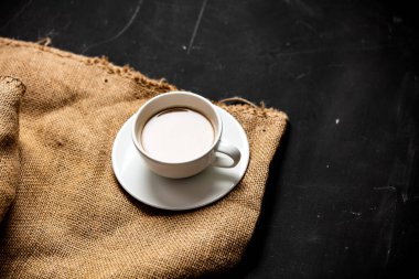 Koyu arkaplanda tahıllar için beyaz kahve ve jüt. 