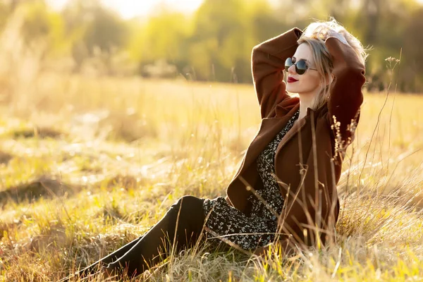 Blondes Mädchen Sitzt Bei Sonnenuntergang Auf Dem Land — Stockfoto