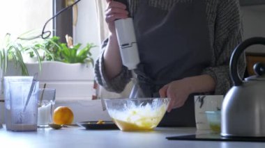 Kadın mutfakta yemek pişiriyor.