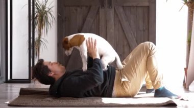 Adam evde köpekle oynuyor.