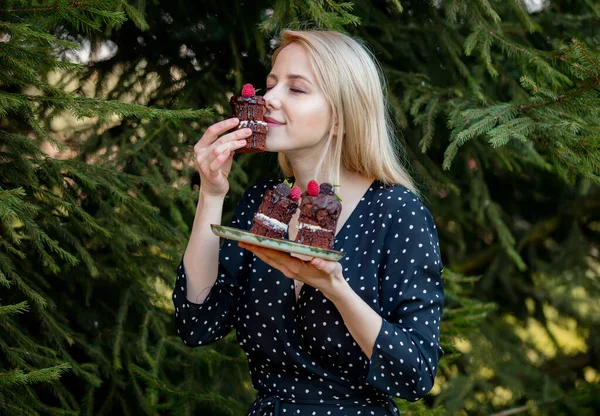 Blondynka Jedząca Ciasto Czekoladowe Jodłą Tle — Zdjęcie stockowe