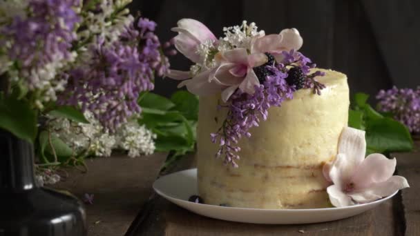 Versierde Witte Bruidstaart Met Lila Magnolia Bloemen Een Tafel — Stockvideo