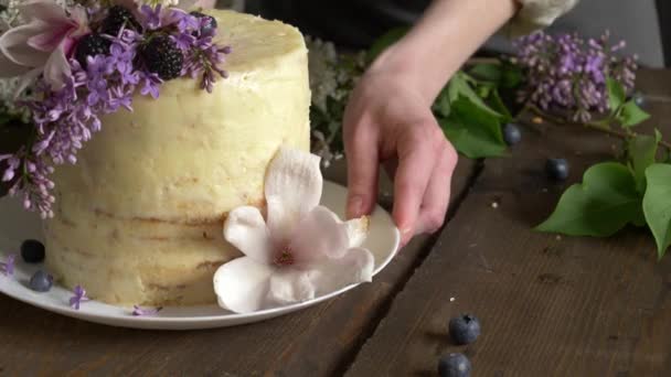 装饰过的白色结婚蛋糕 桌上放着紫丁香和木兰花 — 图库视频影像